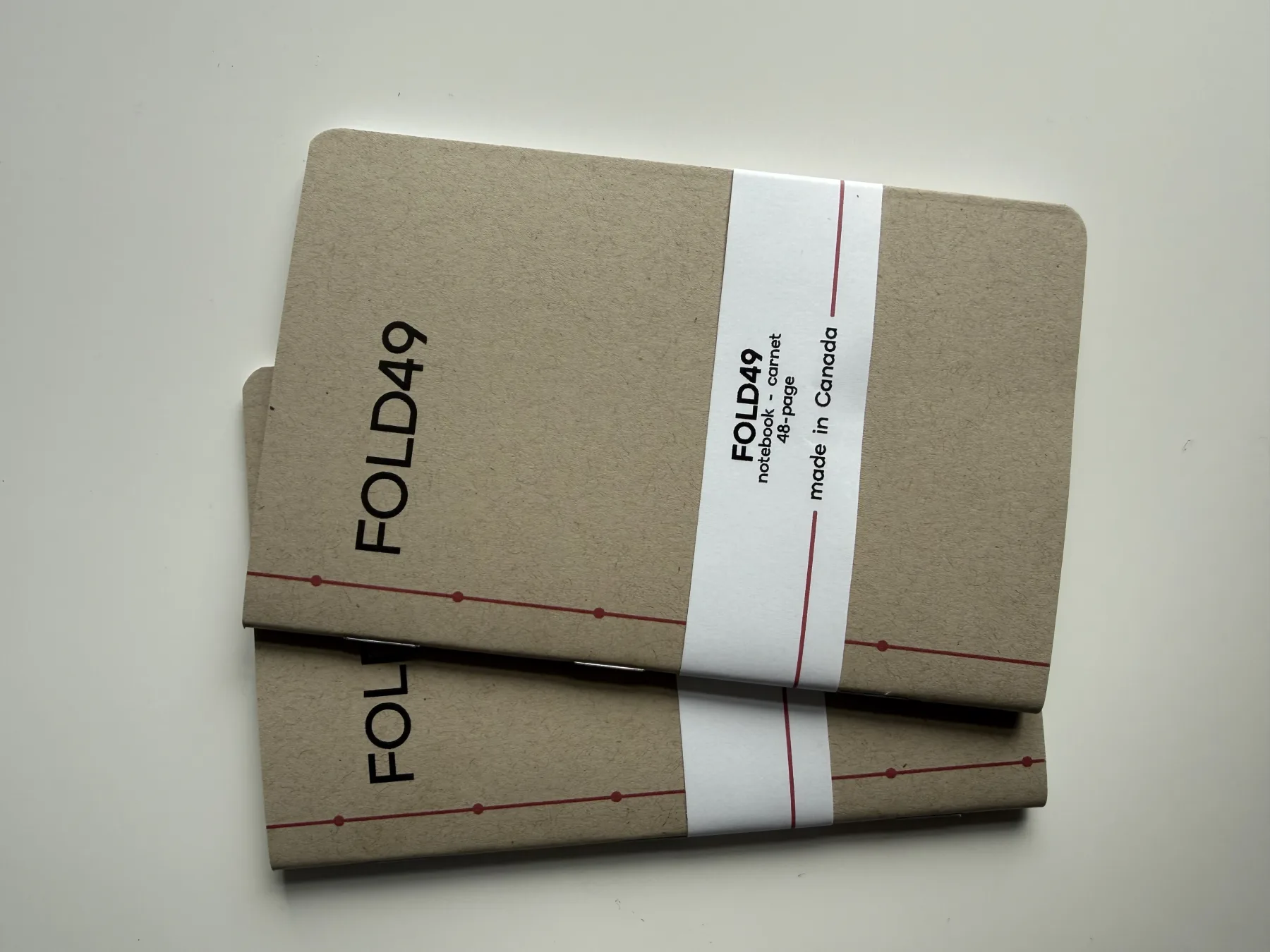 Two FOLD49 notebooks with their front covers and paper bands visible